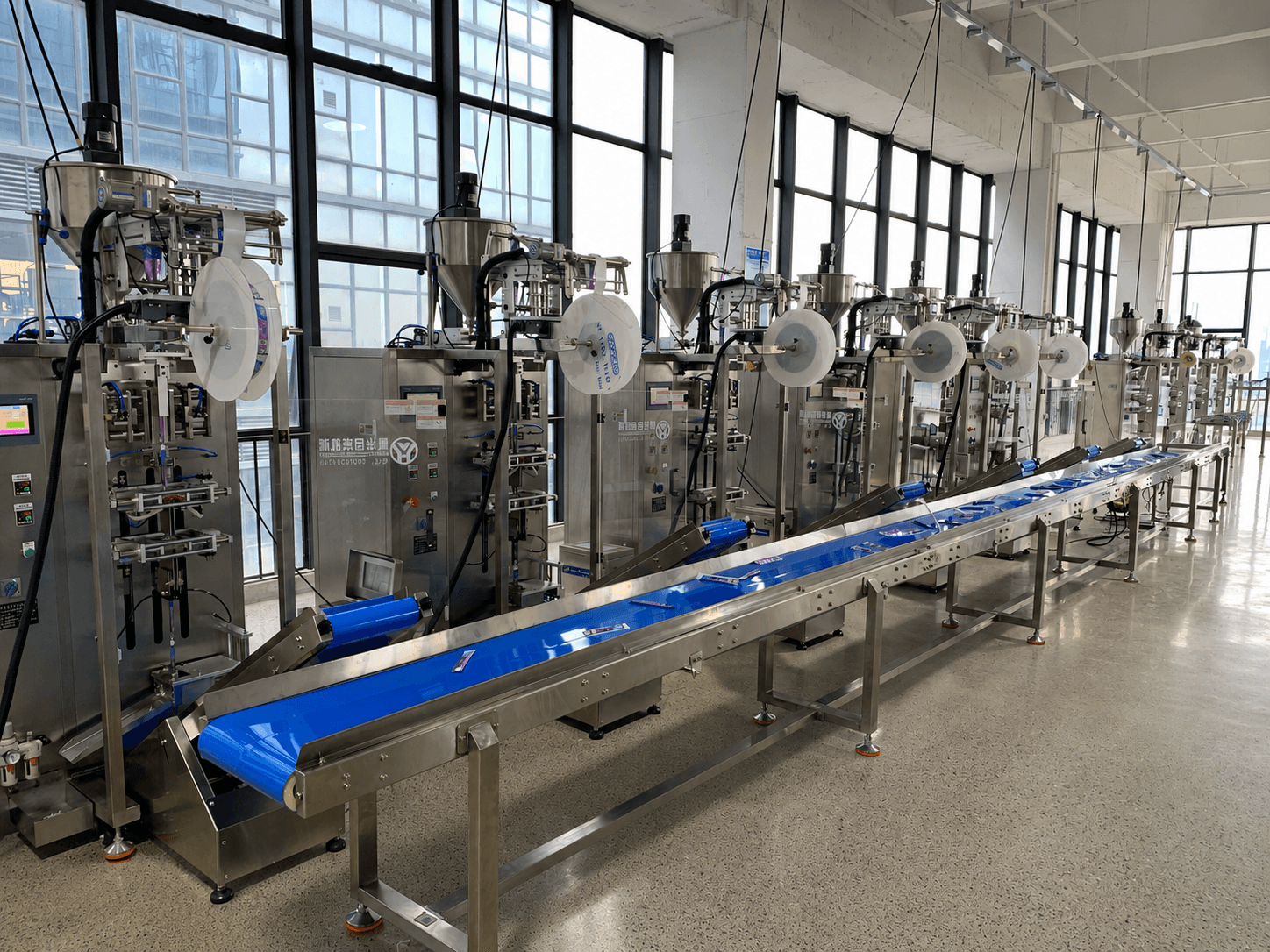 YUHUA packaging machines connected by a blue conveyor system